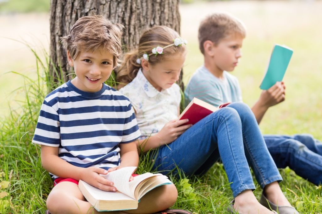 Kids reading books in park